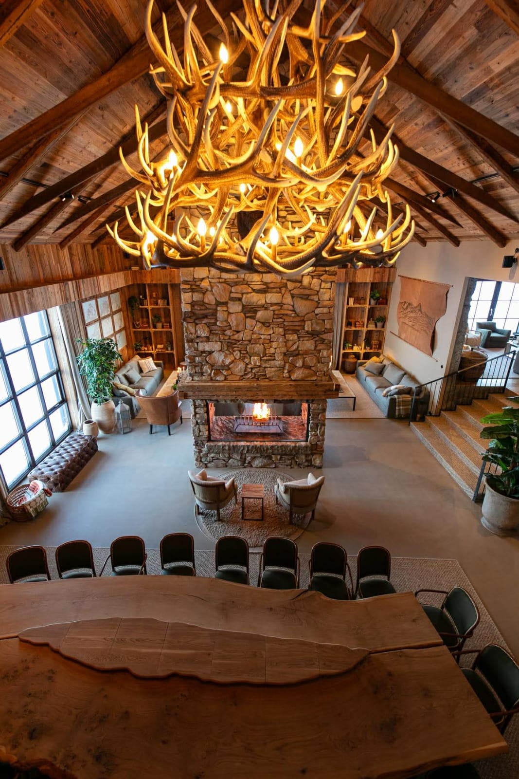 Completed interior lined with warm reclaimed timber around a central stone fireplace